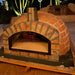 Rustic Pizzaioli Premium Pizza Oven at night with dome and chimney visible